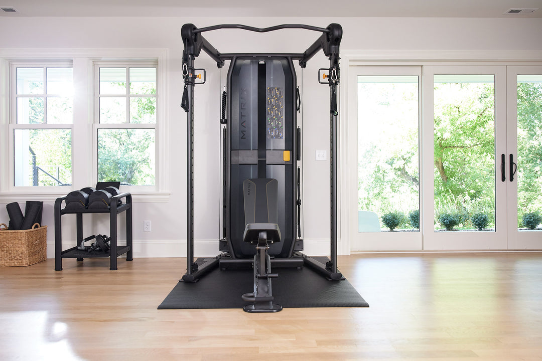 Matrix functional trainer with adjustable pulleys and bench in front view for full body strength training workouts