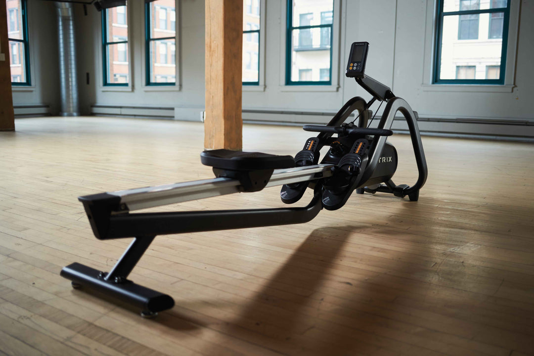 Matrix rowing machine positioned in a home gym workout space.
