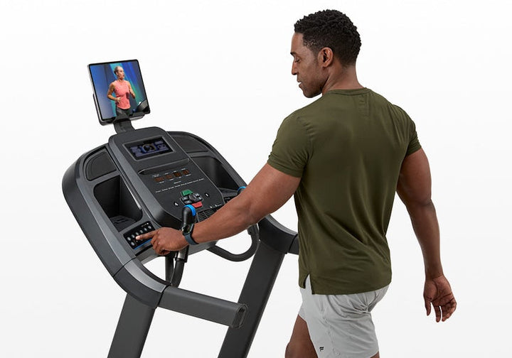 User accessing media controls and tablet holder on the Horizon 7.0 AT treadmill.