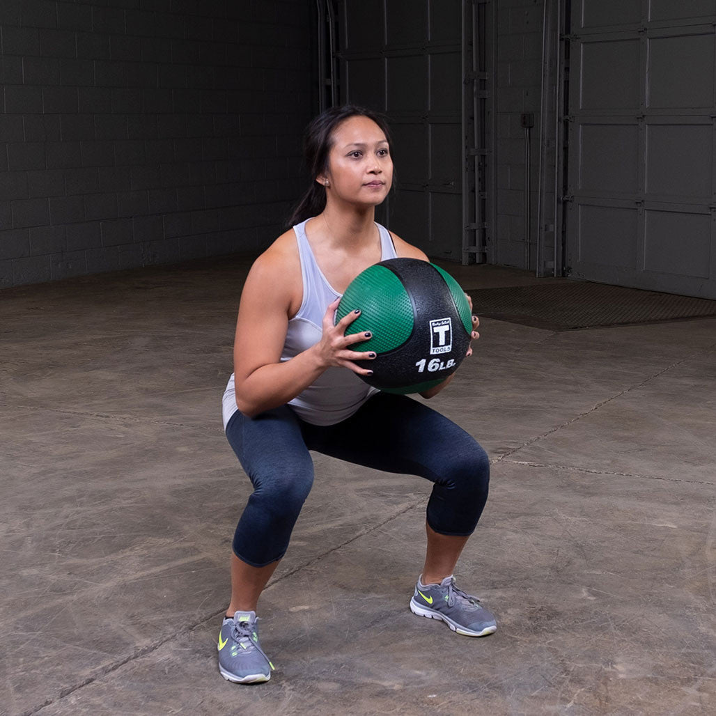 Athlete performing a goblet squat using a premium medicine ball.