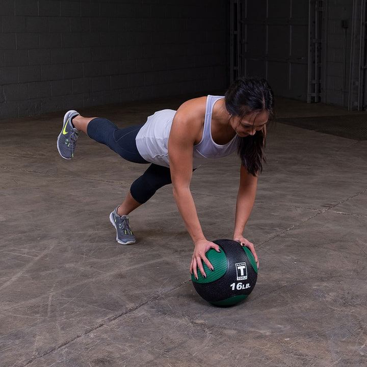 Athlete performing a plank exercise using a premium medicine ball.