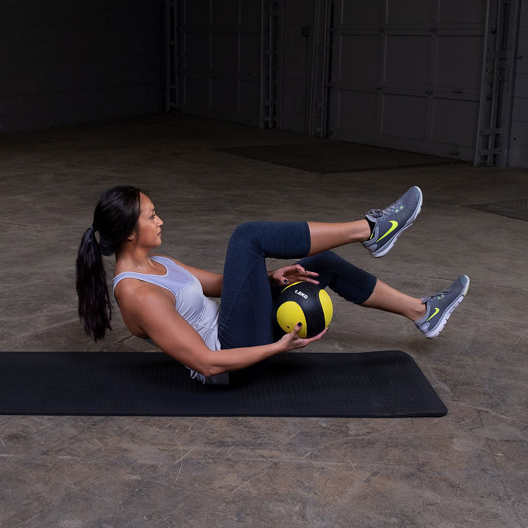 Athlete performing Russian twists using a premium medicine ball.