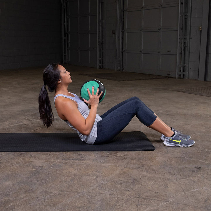 Athlete performing a sit-up while holding a premium medicine ball.