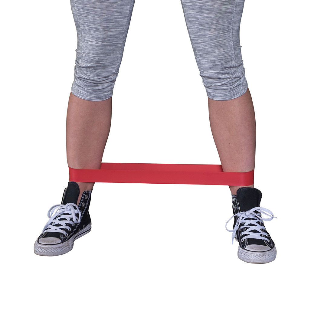Close-up of a lateral stepping exercise using a red Body-Solid Tools mini resistance band.