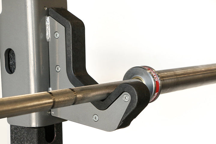 Olympic bar resting securely on the J-cup of the Defiant Strength commercial half rack.