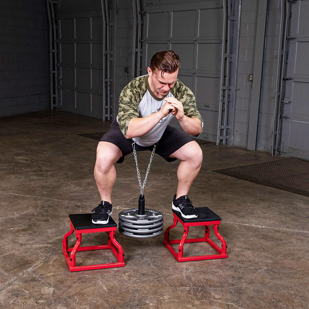 Athlete performing belt squats using the Olympic lifting pin and weight plates.
