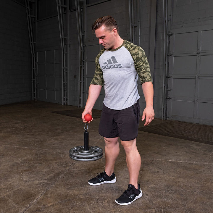 User carrying weight plates with the Olympic lifting pin during strength training.