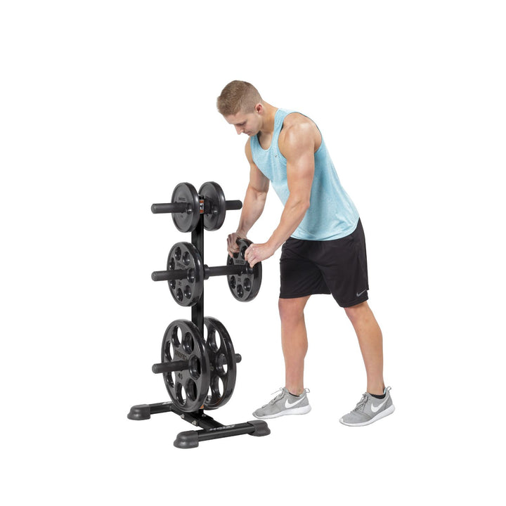 Olympic weight tree side angle with user loading weight plates demonstrating convenient storage and access