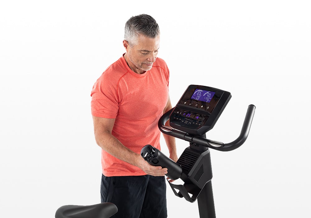 User operating the Horizon 5.0U upright exercise bike console and controls.