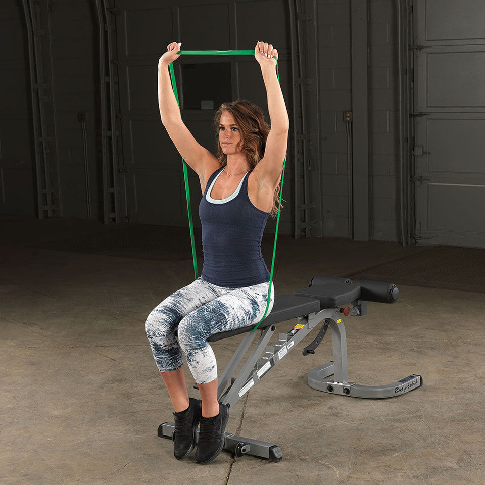 User performing an overhead press exercise with a Body-Solid resistance loop band.