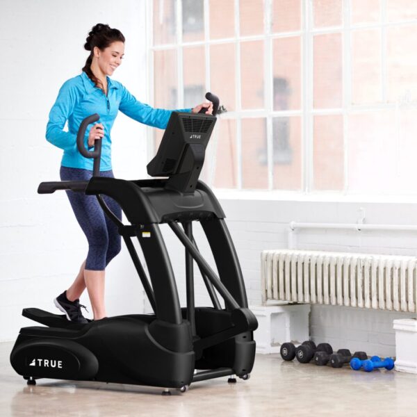 Woman exercising on a TRUE Performance Series elliptical in a home workout setting