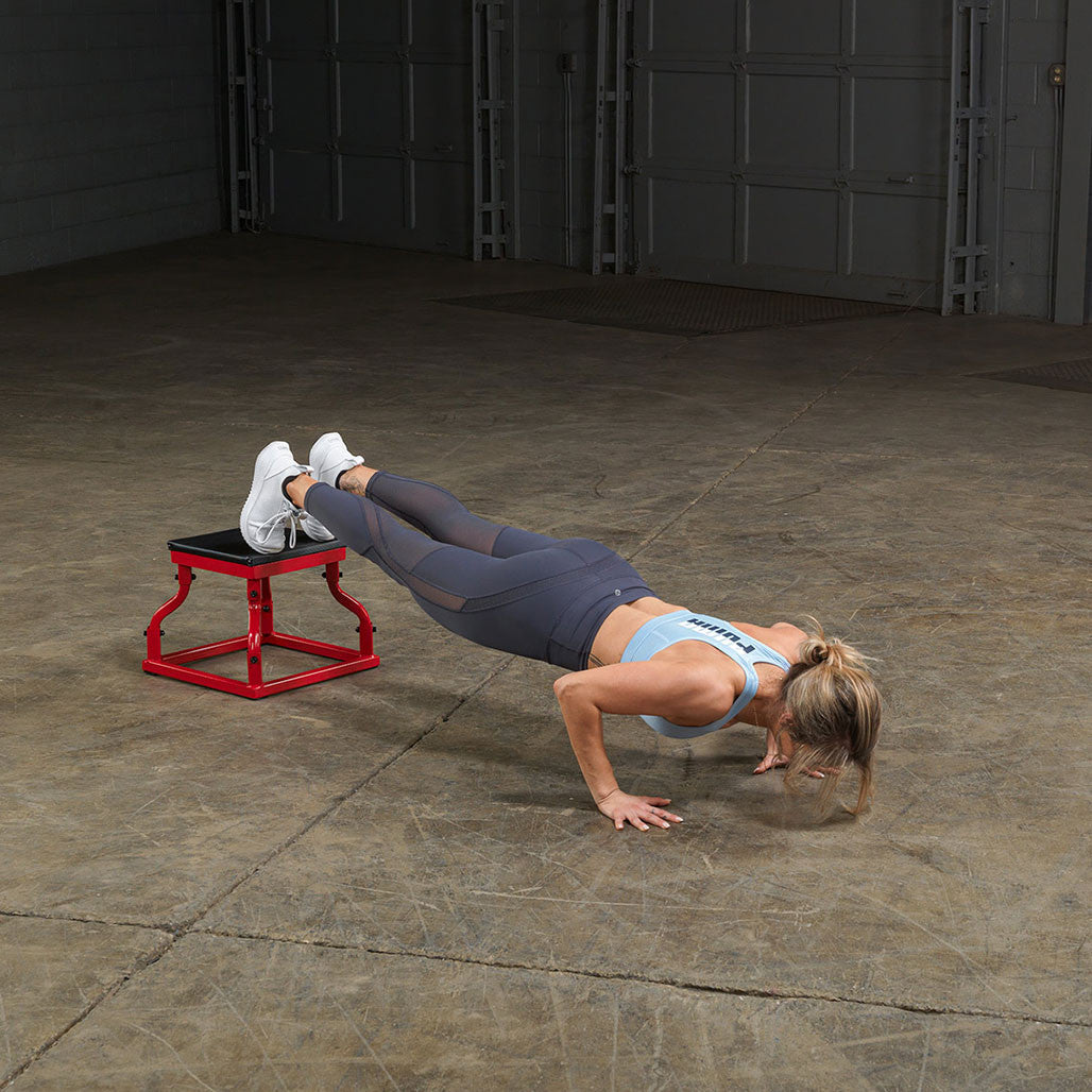 Athlete performing decline push-ups using a steel frame plyo box.