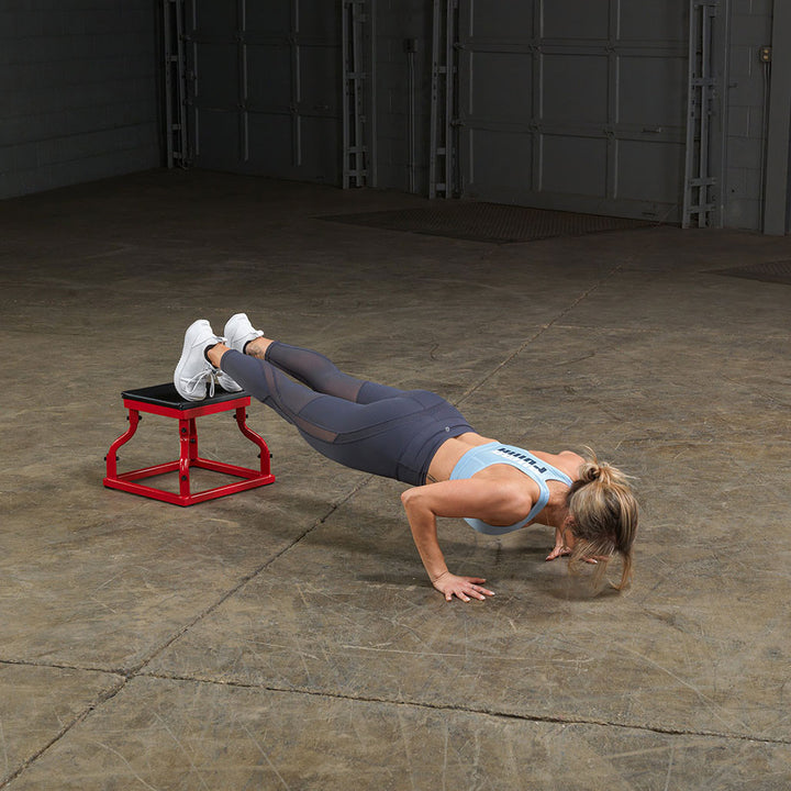 Athlete performing decline push-ups using a steel frame plyo box.