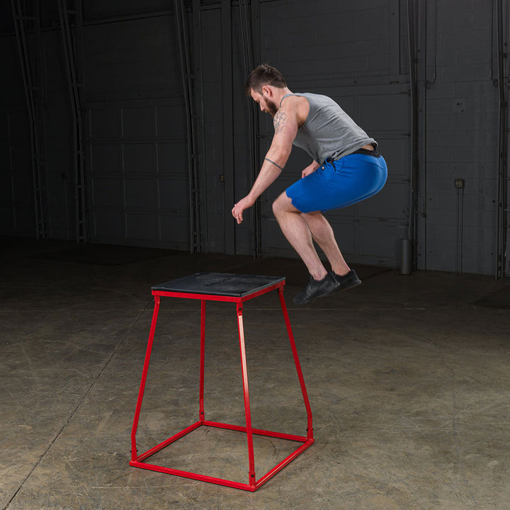 Athlete performing a box jump on a steel frame plyo box.