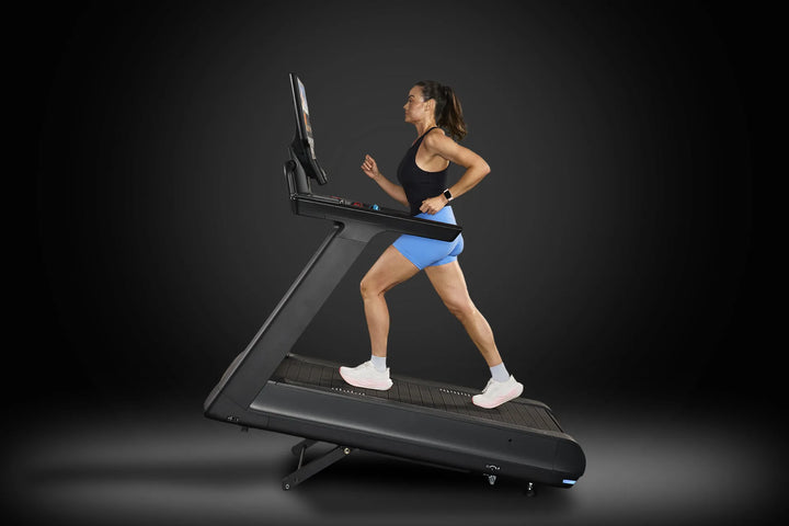 Side view of a user running on the Precor Breakaway treadmill during incline training.