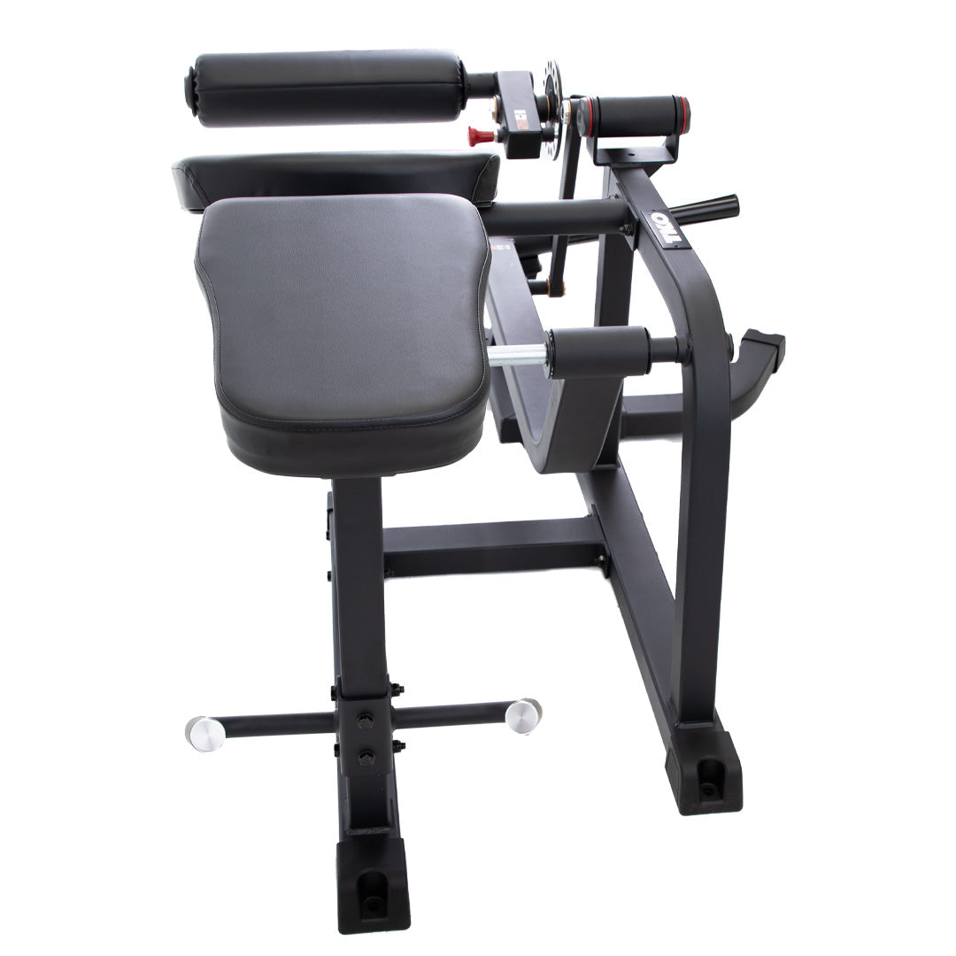 Rear view of prone leg curl machine with adjustable padding and support frame.