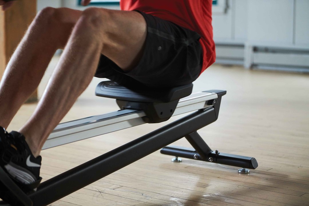 Close-up of the Matrix rowing machine seat and aluminum monorail.
