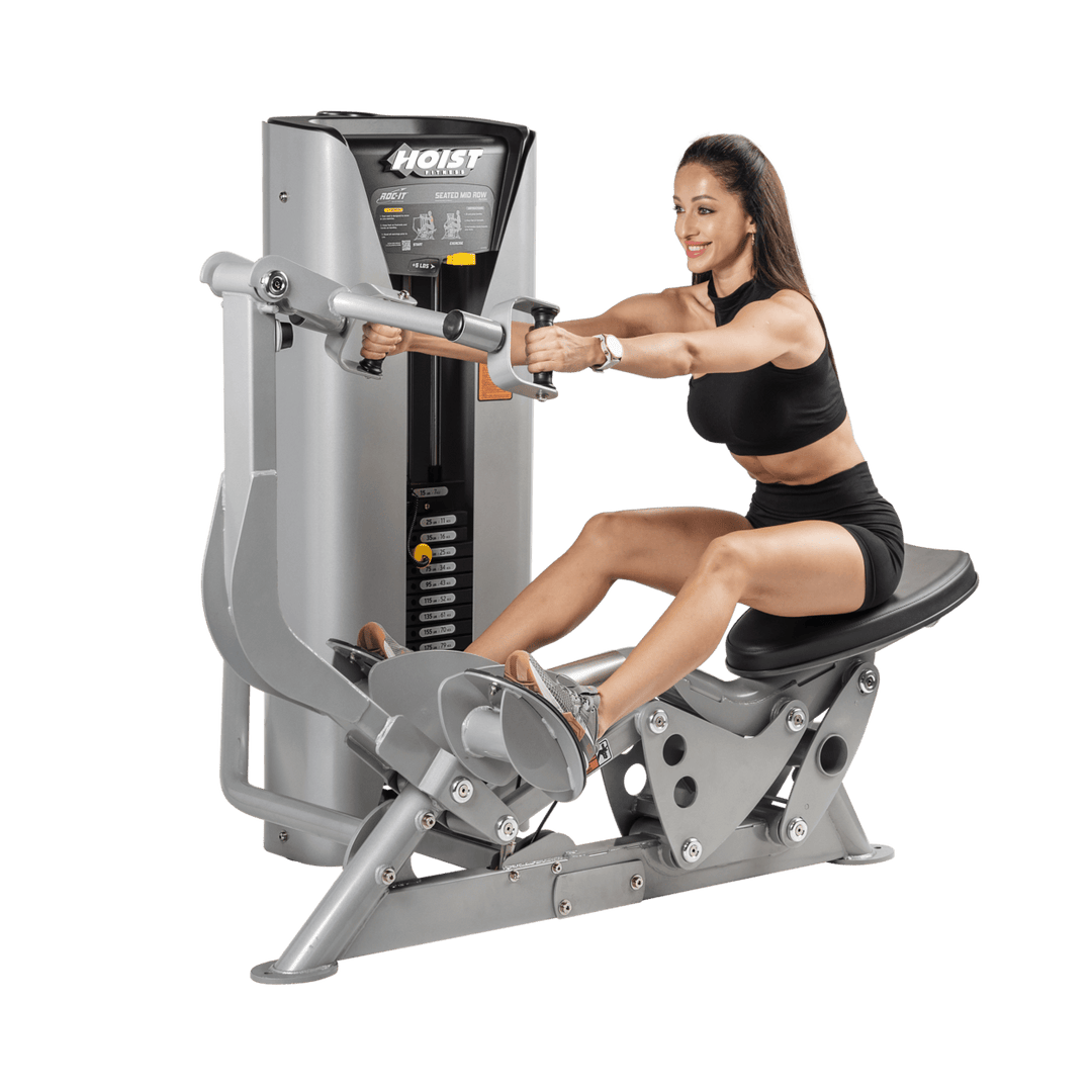 woman seated on mid row machine with arms extended forward demonstrating starting position for back exercise