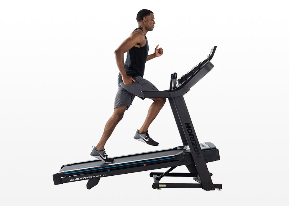 Side view of a person running on the Horizon 7.0 AT treadmill.