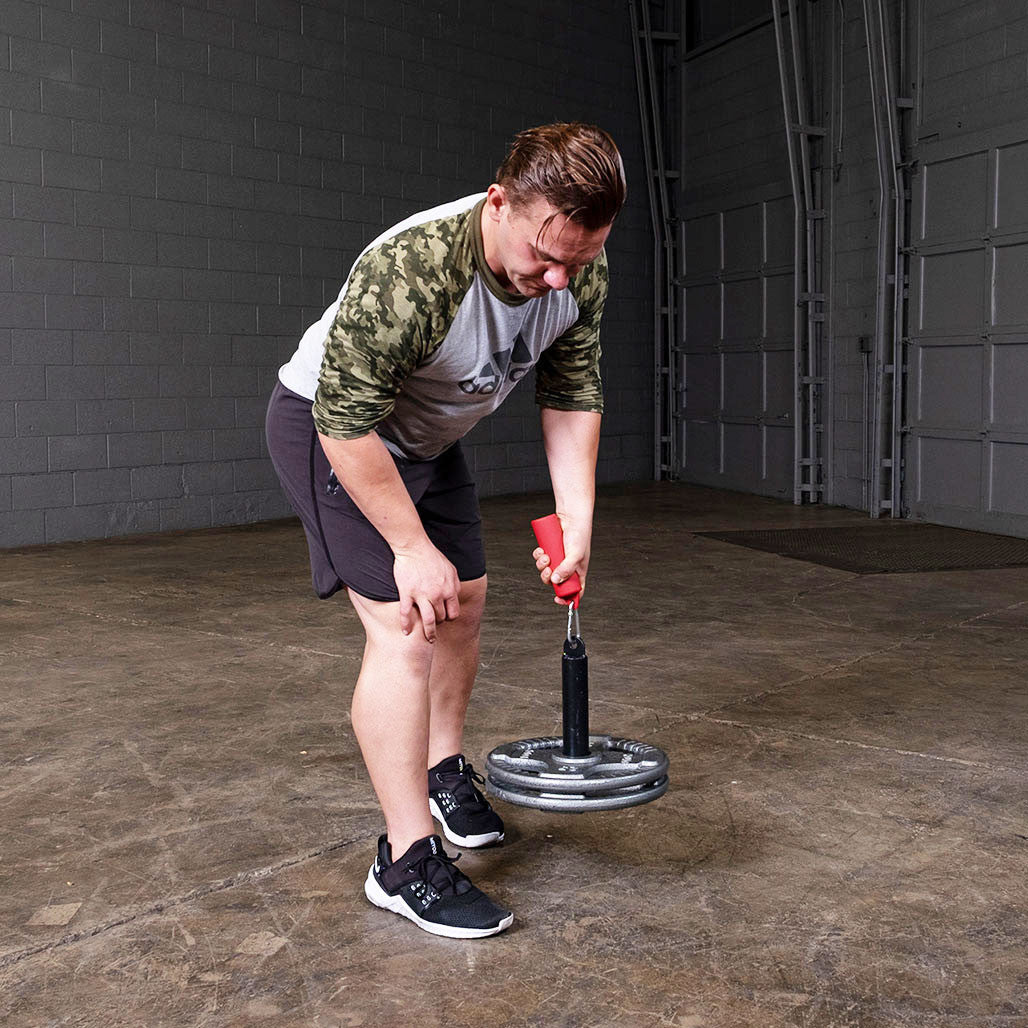 Athlete lifting loaded weight plates with the Olympic lifting pin.