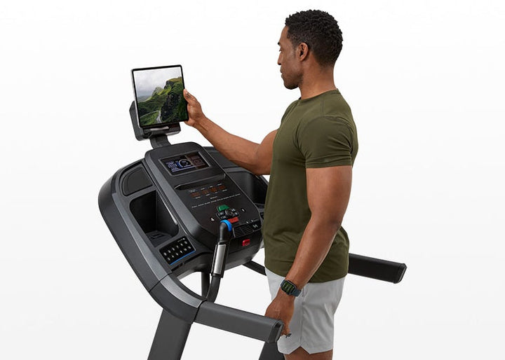 User connecting a smart device to the Horizon 7.0 AT treadmill.