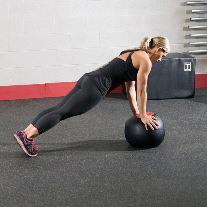 Athlete performing a plank exercise with a Body-Solid soft shell medicine ball