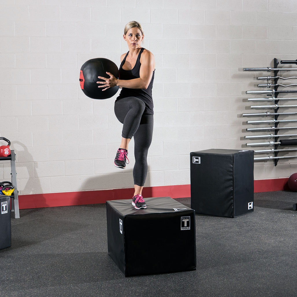 Athlete holding a Body-Solid soft shell medicine ball while performing a step exercise
