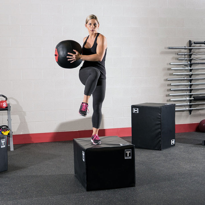 Athlete holding a Body-Solid soft shell medicine ball while performing a step exercise