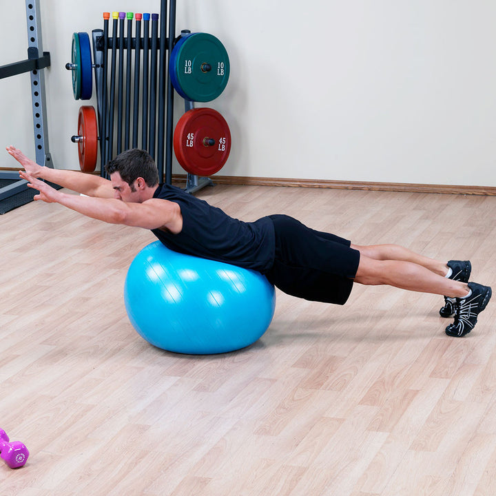 Man performing a plank-style core exercise with a blue Body-Solid stability ball