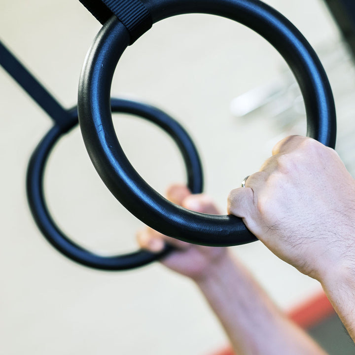 Close-up of a hand gripping a Body-Solid steel gymnastics ring.