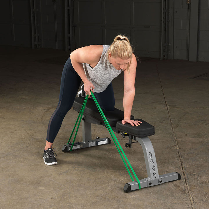 User performing a supported rowing exercise with a Body-Solid resistance loop band.