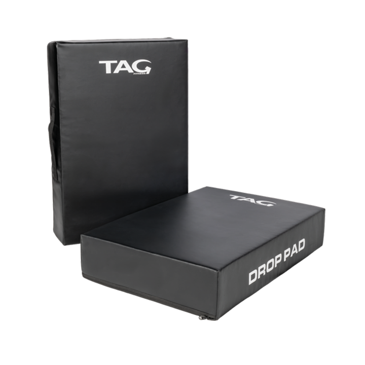 Pair of black TAG barbell drop pads with vinyl surfaces and integrated carrying handles