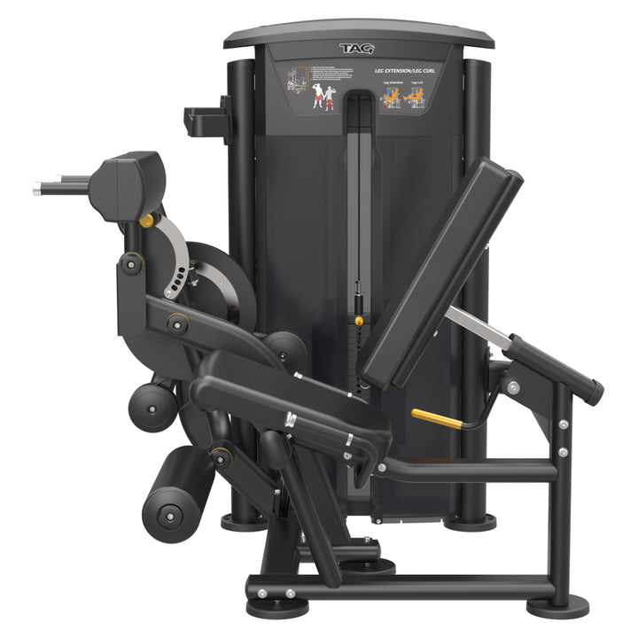Rear side view of TAG Fitness ELITE leg extension/curl machine showing the seat, leg rollers, frame, and weight stack