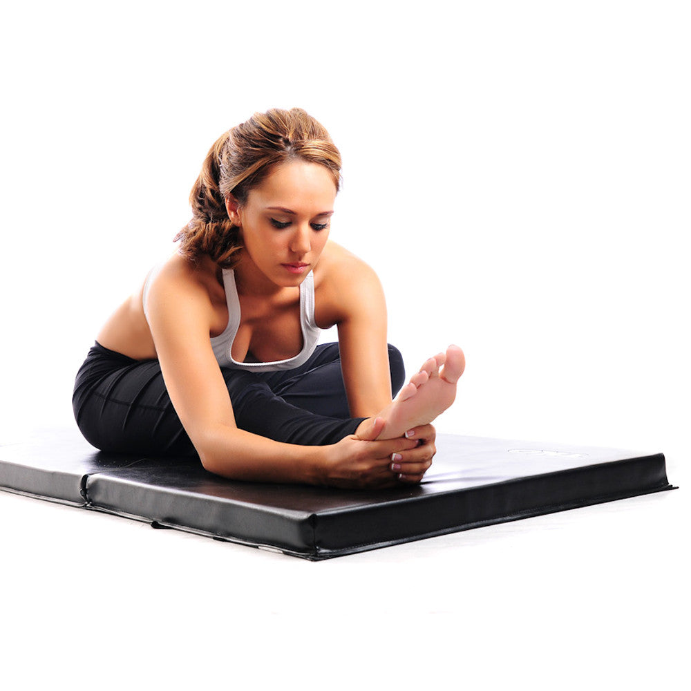 Person performing floor stretching exercises on a TKO folding exercise mat
