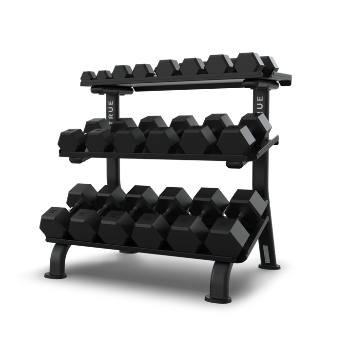 TRUE FS-24 3-tier flat tray dumbbell rack shown loaded with multiple hex head dumbbells