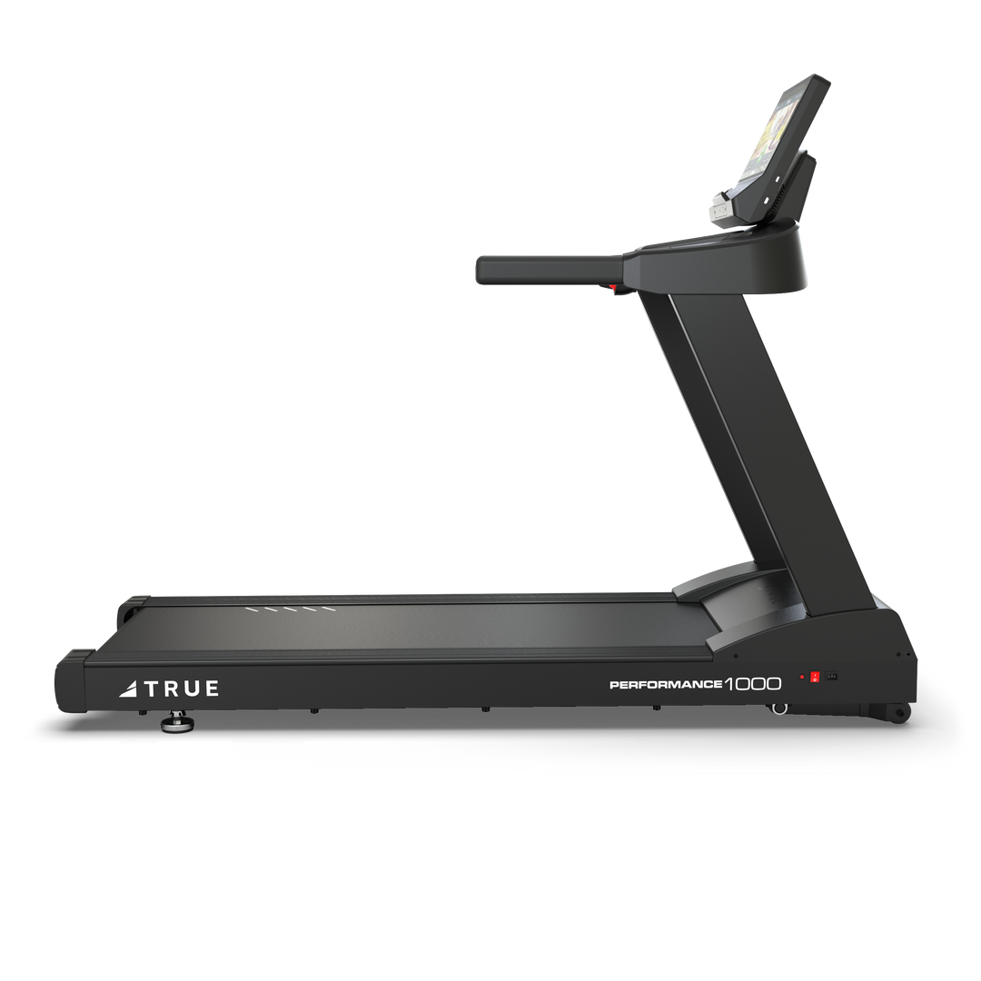 Side profile of TRUE Performance 1000 treadmill showing the running deck, upright frame, and console.
