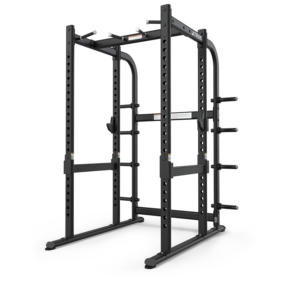 TRUE XFW-7900 power rack shown from a rear angle with pull-up station, catch rails, and plate holders