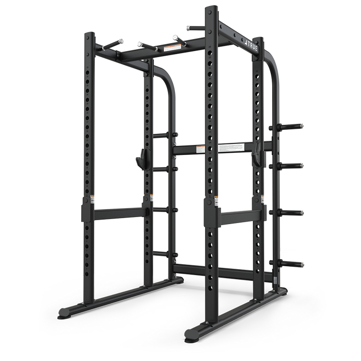 TRUE XFW-7900 power rack shown from a rear angle with pull-up station, catch rails, and plate holders