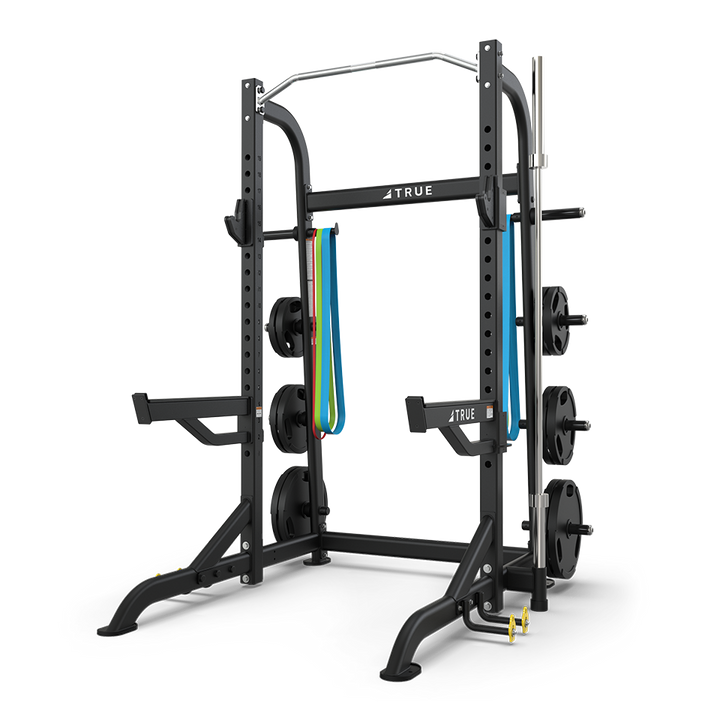 TRUE XFW-8100 half rack with plate holders, Olympic bar storage, pull-up station, and band peg kit shown