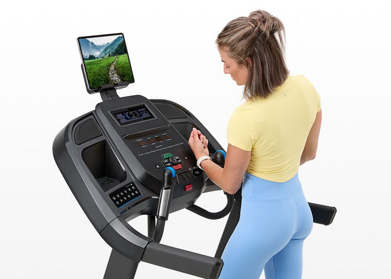User connecting a tablet to the Horizon 7.0 AT treadmill during a workout.