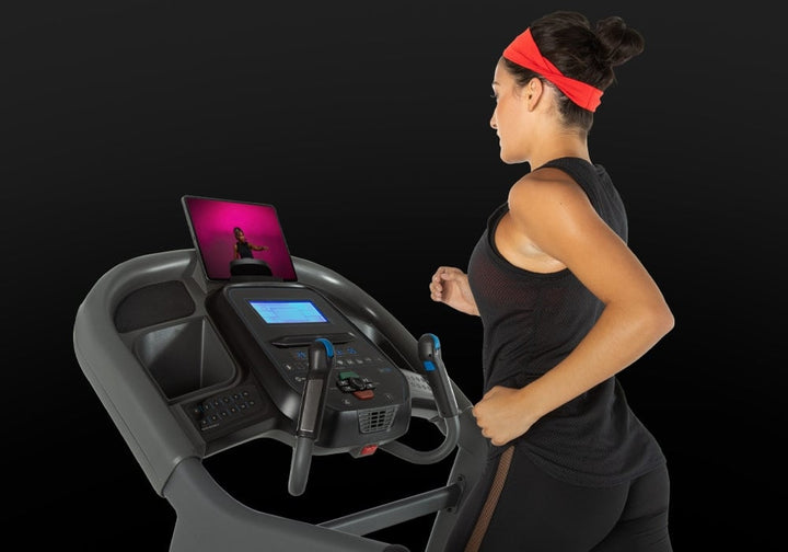 User using the tablet holder and console on the Horizon 7.4 AT treadmill.