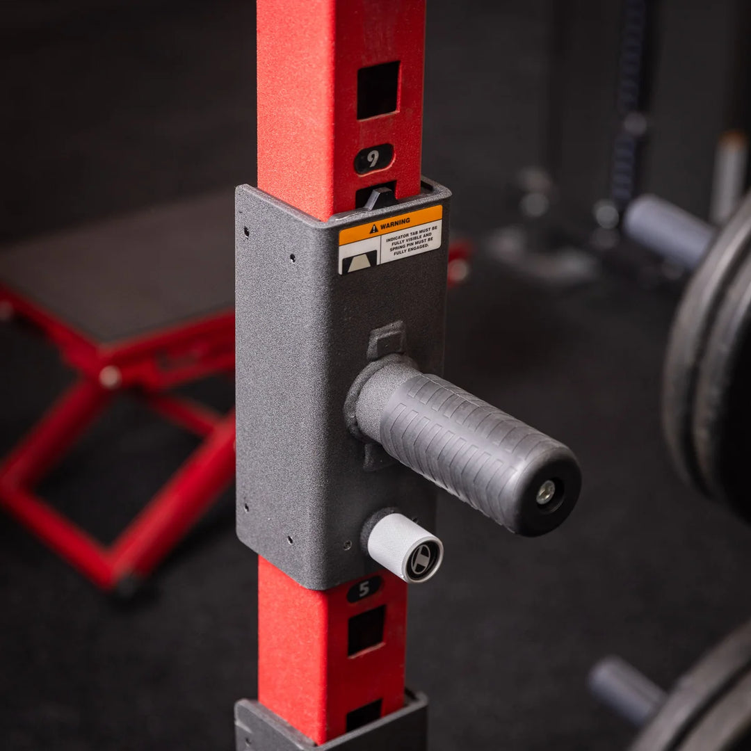 Close-up of black Torque USA squat handle attachment installed on a red gym rack upright with a silver adjustment pin.