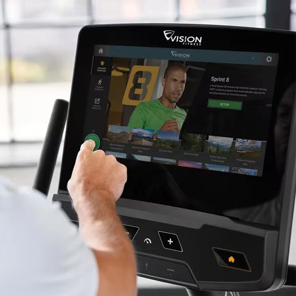 Person operating the touchscreen Entertainment Console on a Vision Fitness R600E recumbent bike