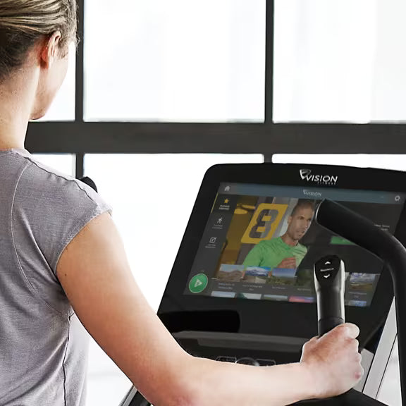 Person using the touchscreen controls on a Vision Fitness S700E Ascent Trainer Entertainment Console