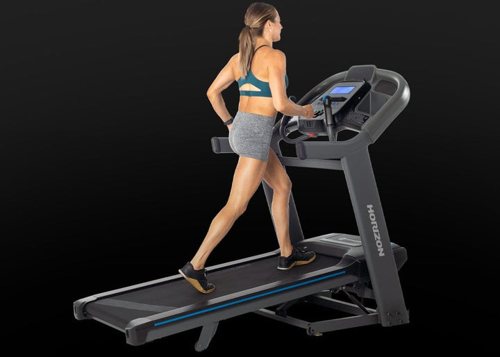 Person walking on the Horizon 7.4 AT folding treadmill.