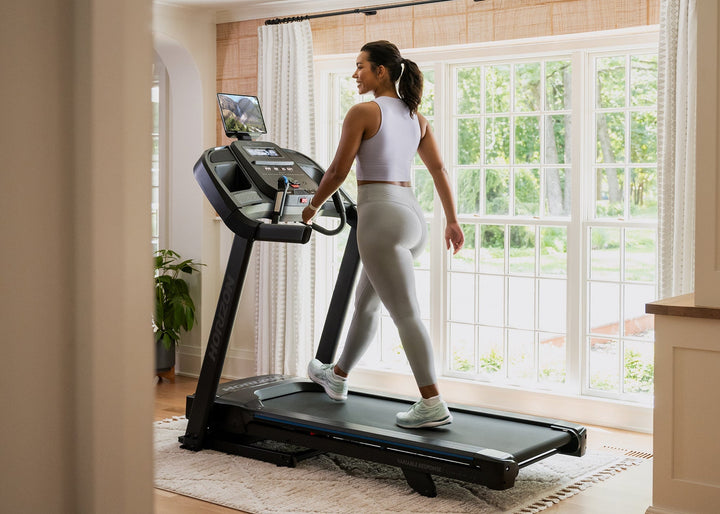 Person walking on the Horizon 7.0 AT treadmill during a home workout.
