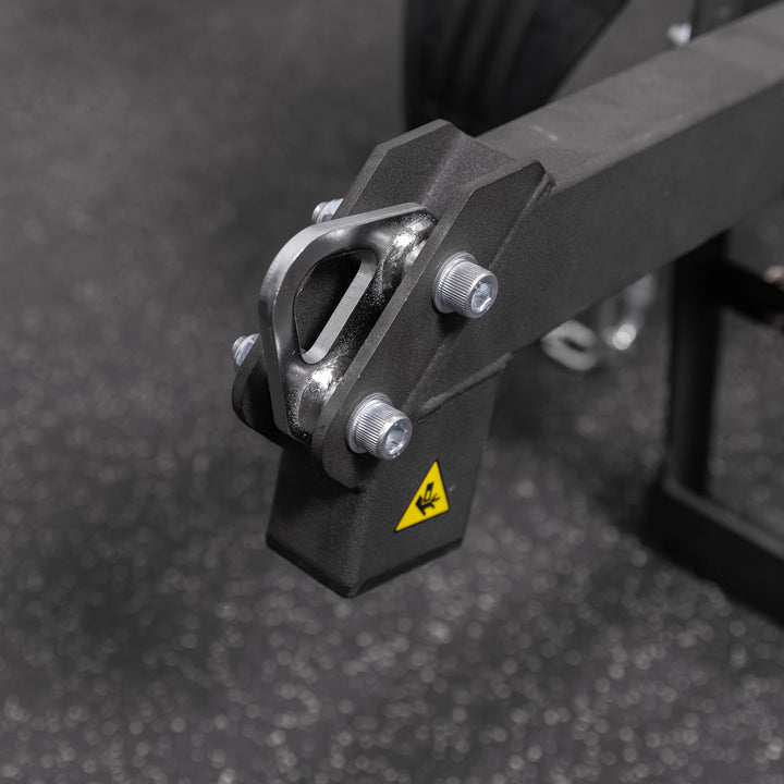 Close-up of the black Torque USA X-CREATE belt squat attachment showing its metal bracket and connection hardware.