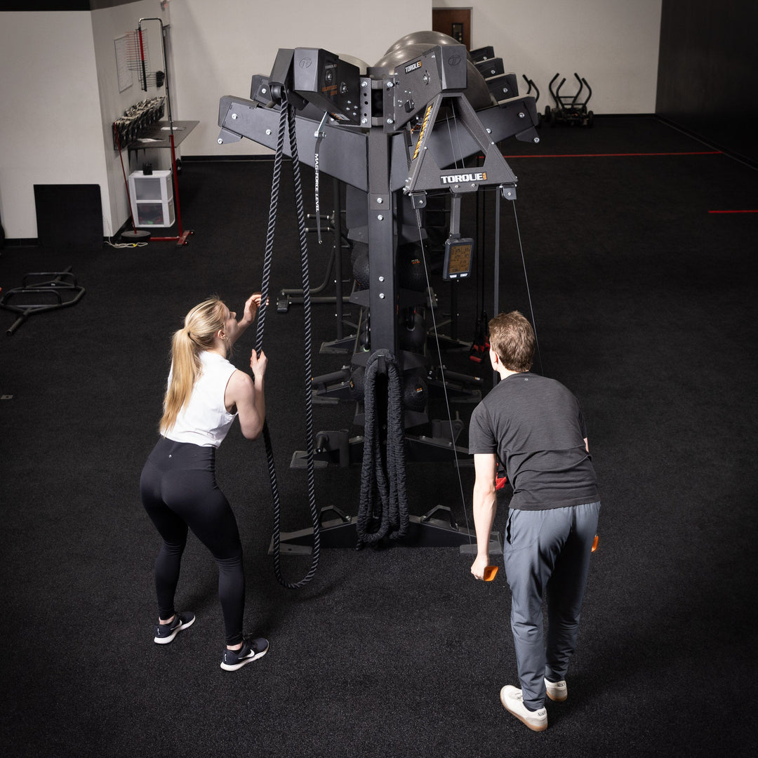 Two people using a gym rope training station with the Torque USA X-CREATE side attachment mount in Black.