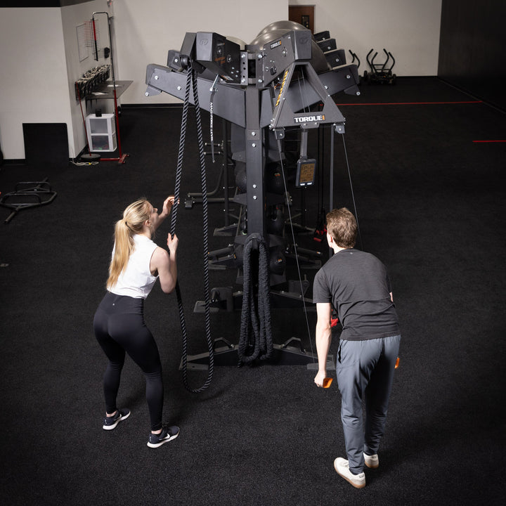 Two people using a gym rope training station with the Torque USA X-CREATE side attachment mount in Black.