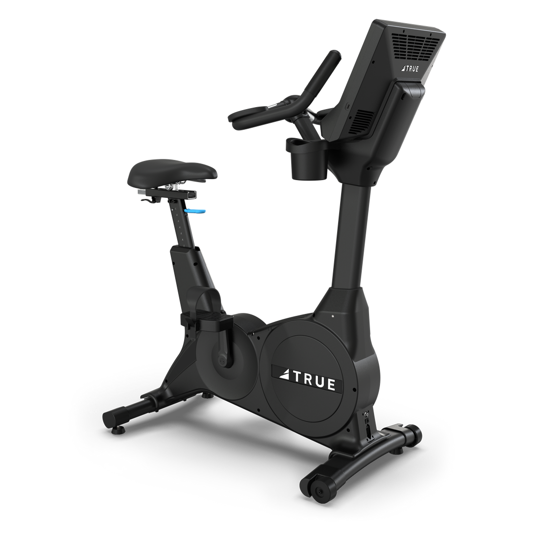 TRUE Fitness upright exercise bike with console and adjustable seat, side view